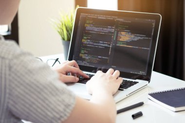 Genç programcı yazılım şirketinin ofisinde yazılım uygulaması geliştiriyor..
