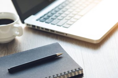 Ahşap ofis masasında dizüstü bilgisayar ve malzemeler sabah ana ofiste olacak..