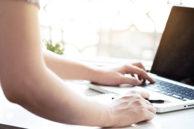 Genç üniversite öğrencisi internetten bir şeyler ararken ondan bir not alıyor..