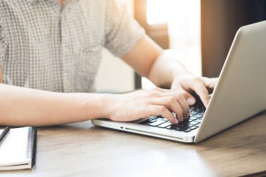Genç üniversite öğrencisi dizüstü bilgisayarda klavye kullanıyor. İnternet araştırma kavramı.