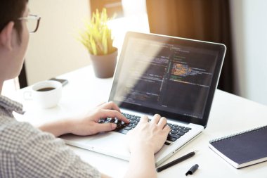 Genç programcı yazılım şirketinin ofisinde yazılım uygulaması geliştiriyor..