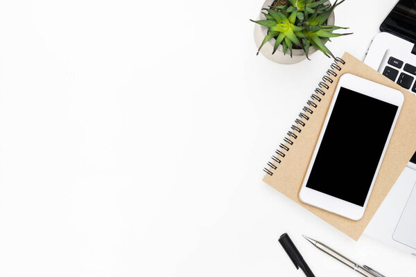 Смартфон с чистым экраном находится на ноутбуке поверх белого стола офиса. Вид сверху с копировальным пространством, плоская кладка.