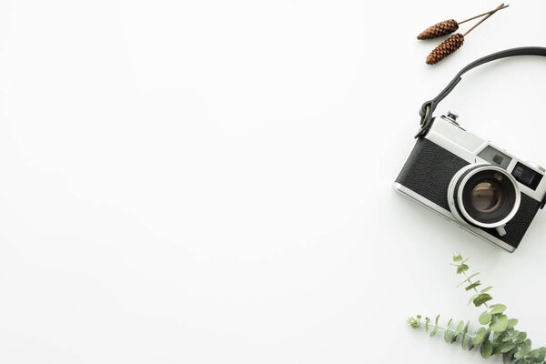 White minimal hipster photographer office desk table with retro film camera. Top view with copy space, flat lay.