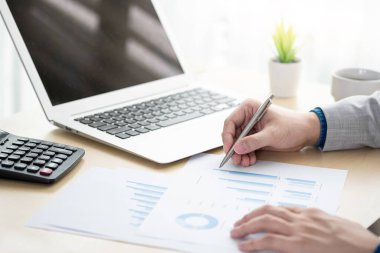 İş adamı mali raporları denetlemek için iş raporlarını inceliyor. Gelirleri analiz etmek ve bütçe konseptini denetlemek.