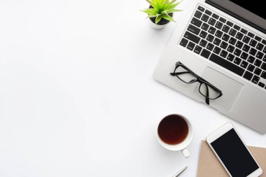 Boş ekranlı akıllı telefonlu ahşap ofis masası, dizüstü bilgisayar, kahve ve malzemeler. Kopyalama alanı olan üst görünüm, düz yatay.