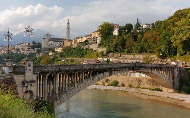 İtalya Belluno 'nun silueti, ön planda Piave nehri üzerindeki Vittoria köprüsü.