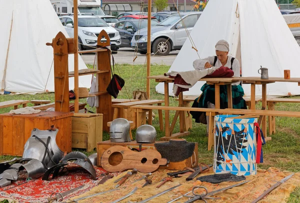 CORMONS, İtalya - 17 Ağustos 2019: Tarihi yeniden canlandırma sırasında bir kampta dikiş diken kız