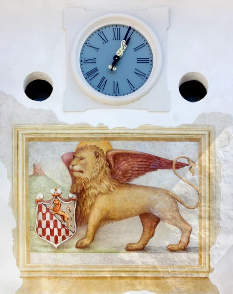 Lion à ailes vénitiennes et horloge sur la porte de la ville à Spilimbergo — Photo