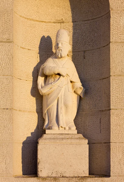 Standbeeld op de gevel van de kerk van een land — Stockfoto