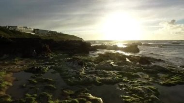 Rockpools ve deniz yosunu ortaya çıkarmak için gün batımında çıkıyor dalganın dikey pan
