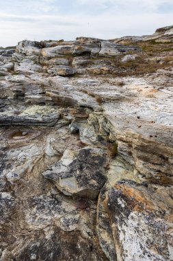 Doğal deniz kıyısı taşları ve kayalık kaya, Arktik Okyanus kıyısı Varanger yarımadası, Finnmark, Norveç