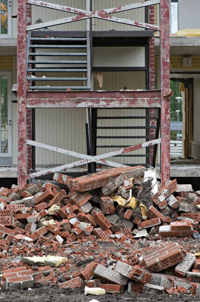 Куча Кирпичей Перед Частично Разрушенным Домом — стоковое фото
