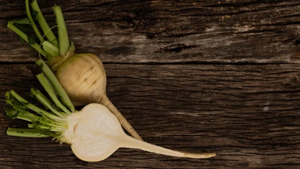 El nabo blanco cortado con tapas se encuentra en viejas tablas de madera. Útil raíz vegetal cultivada en el jardín — Foto de Stock