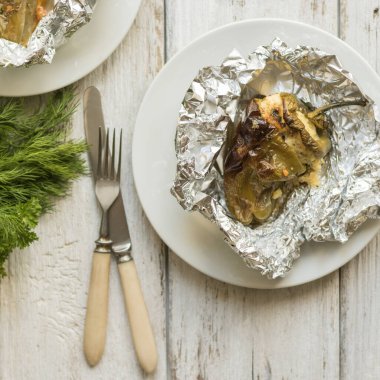 Biberler süzme peynir, peynir, otlar ve sarımsak ile doldurulmuş, folyoda pişirilmiş. Etsiz lezzetli sağlıklı yiyecekler..