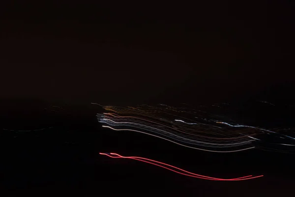 都市景観での移動中のトラフィックの車のライトトレイル 露出で撮影された写真 — ストック写真
