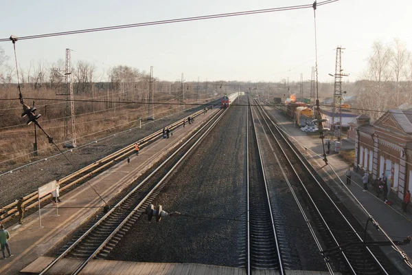 AKSAKOVO, REPÚBLICA DE BASHKORTOSTAN, RUSIA, 16 DE ABRIL DE 2021: La gente se encuentra con el tren de los Ferrocarriles Rusos en la estación — Foto de Stock