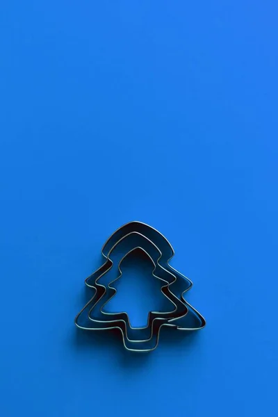 Christmas tree in the shape of cookies. Monochrome blue color and minimalism. New Year greetings and kitchen tools. — Stock Photo, Image