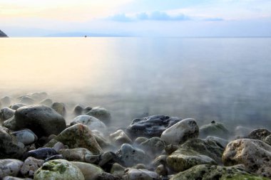 Deniz kıyısı. Kayaları yalayan deniz dalgaları.