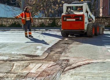 İşçi trafik iş freze yol yüzeyi sırasında denetler.