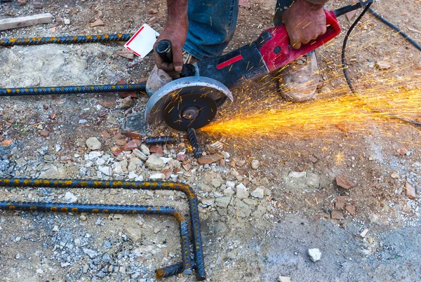 Trabalhador da construção corta vergalhões serra circular no local . — Fotografia de Stock