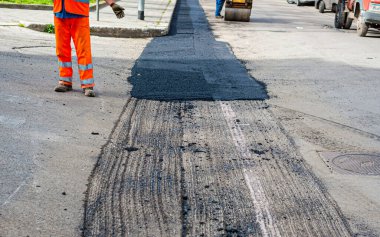 İşçi nakliyeciler, fiber optik hattın inşaatından etkilenen bir kavşakta araç dolaşımını düzenler.