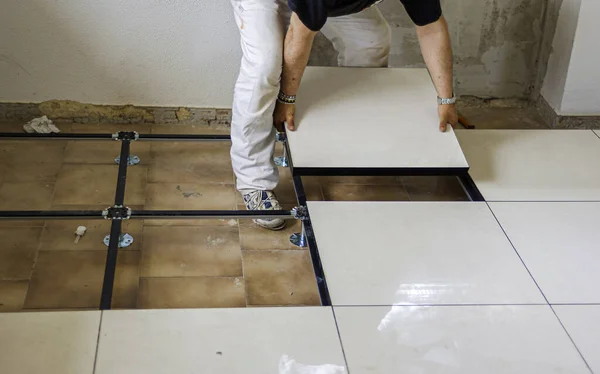 Worker install of raised floor in equipment room to spare space underground