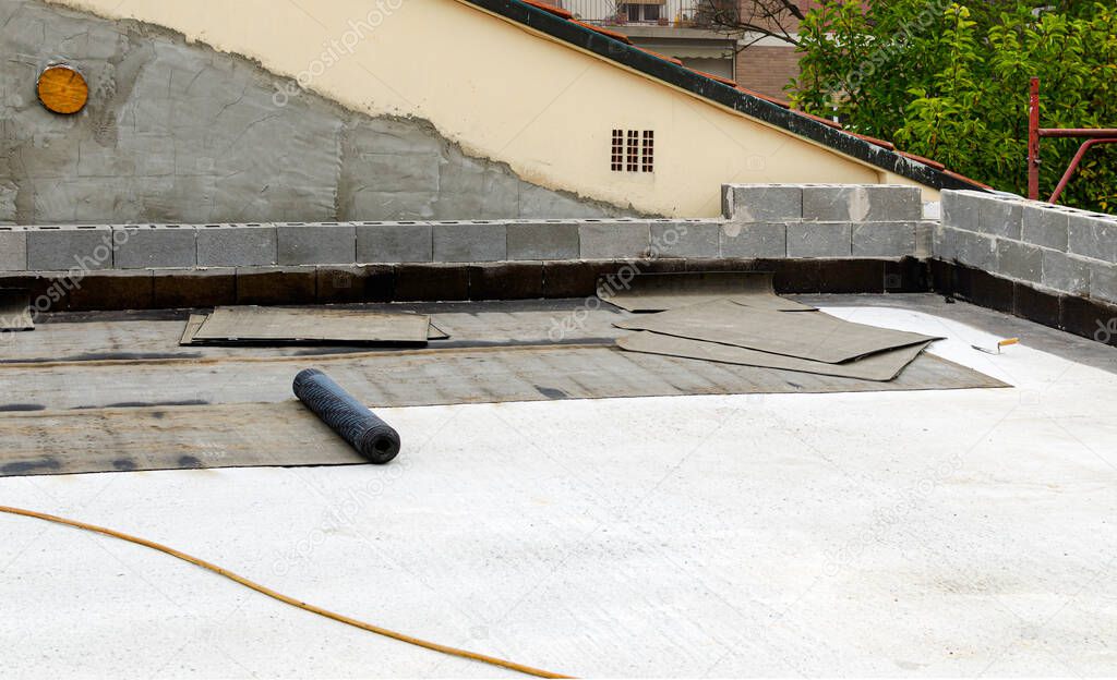 gas burner and roll of roofing material on blurred background