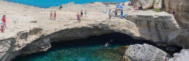Roca Vecchia, İtalya - 8 Haziran 2019: Apulia 'da tatil. Şiir Mağarası (Grotta della Poesia). Doğal havuzun çevresindeki insanlar, Roca vecchia - Apulia. İtalya