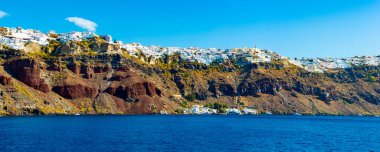 Santorini 'nin sahil kayalıklarının el kamerası görüntüsü. Sudaki bir tekneden görüldüğü gibi..