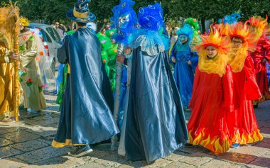 Corato, İtalya - 4 Şubat 2018: Puglia 'da bir şehrin sokaklarında maskeli grupların geçit töreni sırasında güzel ve renkli giysileri olan genç insanlar ve çocuklar. İtalya