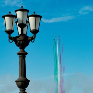 Bari, İtalya - 8 Mayıs 2020: İtalyan akrobatik takımı Frecce Tricolori (Tricolor okları), St. Nicholas bayramında Airshow 'u icra eder. Bari rıhtımının karakteristik elektrik direği görünür.