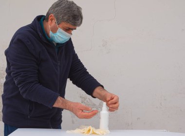 İnsan koronavirüs enfeksiyonunun yayılmasını önlemek için beyaz lateks eldiven giyer.