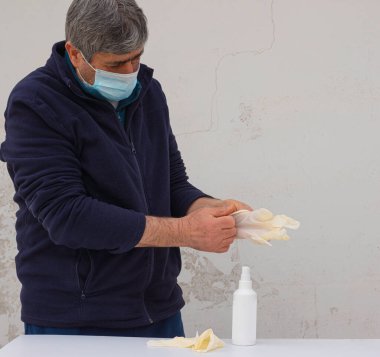 İnsan koronavirüs enfeksiyonunun yayılmasını önlemek için beyaz lateks eldiven giyer.