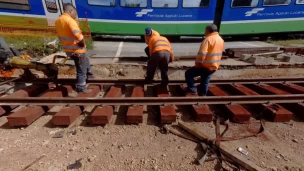 Modugno イタリア 4月1 2019 プーリア州Modugno駅近くの鉄道線の再建作業のための労働者と運転機械 低速度で他のトラック上の鉄道輸送隊が前進します — ストック動画