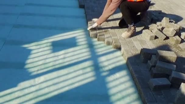 建筑工人将相互关联的铺装混凝土铺在无纺布床砂上 并将其安装到位 — 图库视频影像