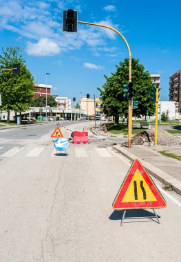 Bari, ITALY - 20 Nisan 2016: Turuncu bayraklı trafiği yöneten turuncu giysili adamla sokak inşaat bölgesi