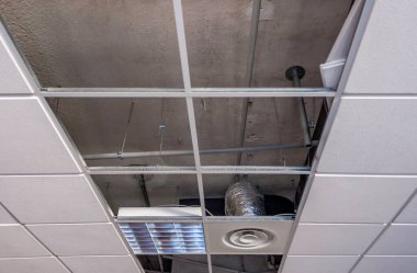 Sınıfta alçıtaşıyla asılı bir tavanda tamir işi.