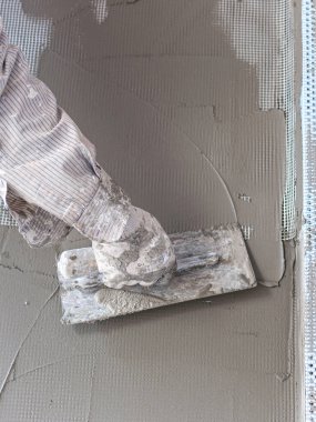 İnşaat işçileri evin ön cephesini alçılıyor. İşçi sıva aracı alçı mermer iç alçı kaba