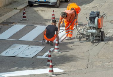 Modugno, İtalya - 9 Ekim 2017: makine ve yol yapımı işçi yol için kullanın ve boyama işareti trafik trafik polis verir