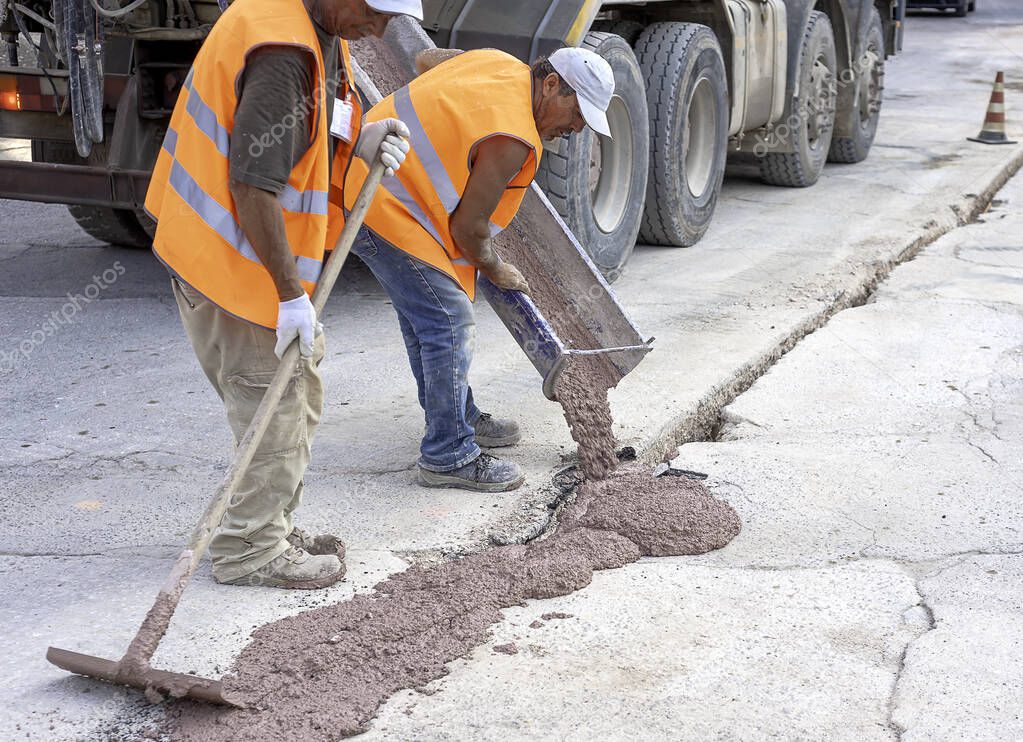 fiber optic cables buried in a micro trench with concrete colored red by a worker