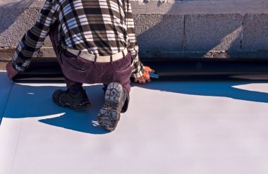Sentetik su geçirmez PVC-P ve TPO / FPO uygulaması üzerinde çalışan işçiler