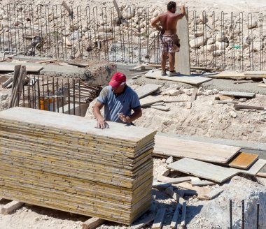 İnşaat işçileri inşaat alanında yer kirişi döşeme işi yapıyorlar.