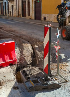 Taç aksesuarlı mini kazıcı, optik liflerle altyapı inşaatı için mini siper hazırladı.