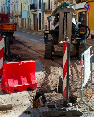 Taç aksesuarlı mini kazıcı, optik liflerle altyapı inşaatı için mini siper hazırladı.