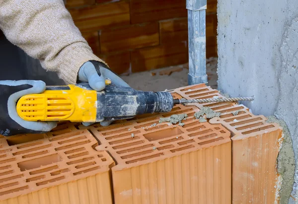 Mason drills a hole with a power drill — Stock Photo, Image