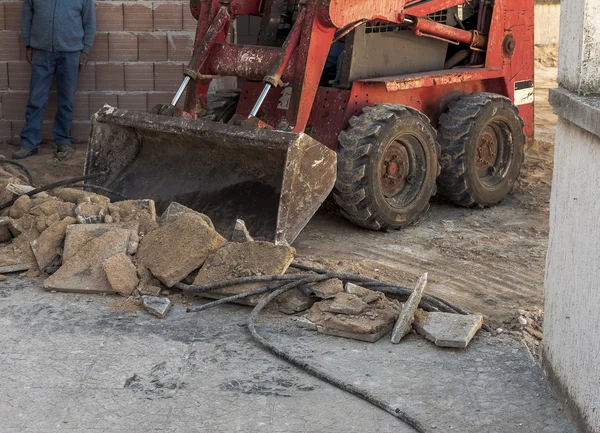 Trabalhador da equipe remoção de piso antigo com mini escavadeira — Fotografia de Stock