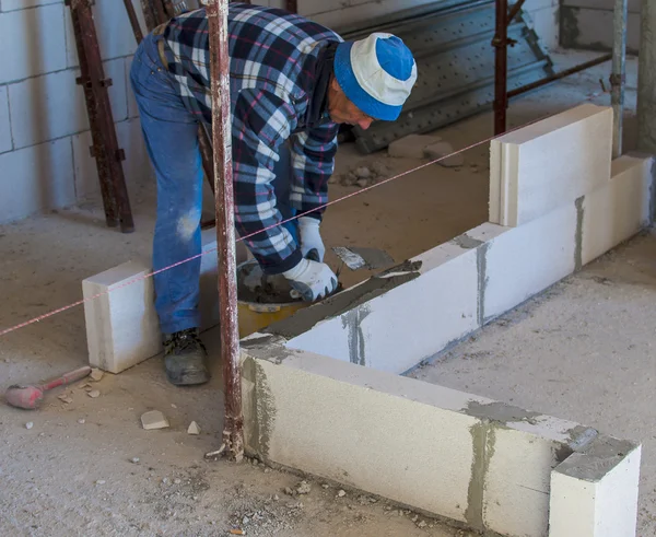 Arbetaren utför en intern murare vägg — Stockfoto