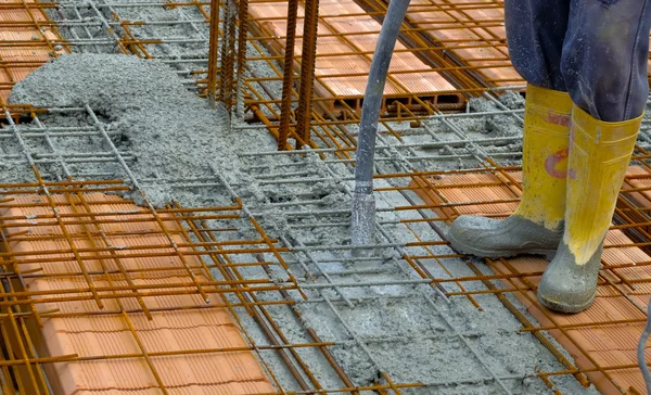 Trabalhador da construção civil compactação de cimento líquido em forma de reforço — Fotografia de Stock