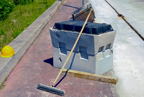 Bloco de poço pré-moldado concreto, capacete e escova de limpeza — Fotografia de Stock