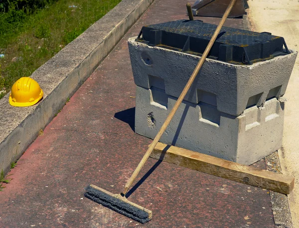 Bloco de poço pré-moldado concreto, capacete e escova de limpeza — Fotografia de Stock